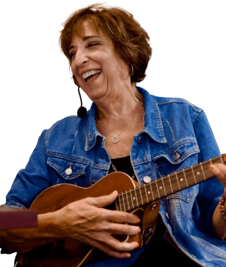 A joyful woman playing a guitar and laughing.