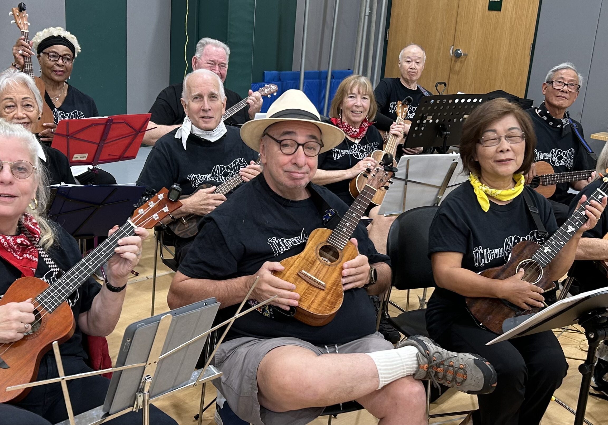 Group of musicians playing ukuleles together indoors.